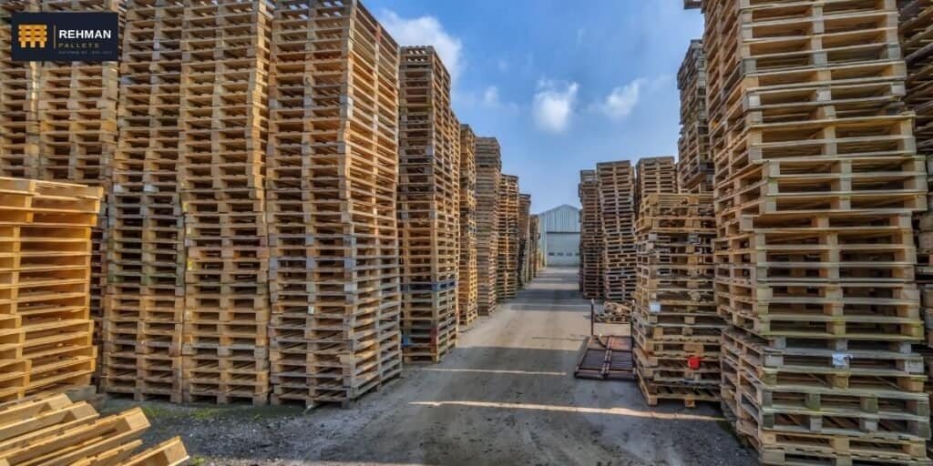 Complete Pallet Guide 8 Massive stacks of wooden pallets prepared for bulk commercial delivery, forklifts loading trailers, industrial storage yard, drone perspective, realistic commercial photography.